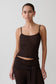 Woman wearing a brown boucle sleeveless top.