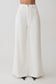 Woman wearing white wide-leg pants.