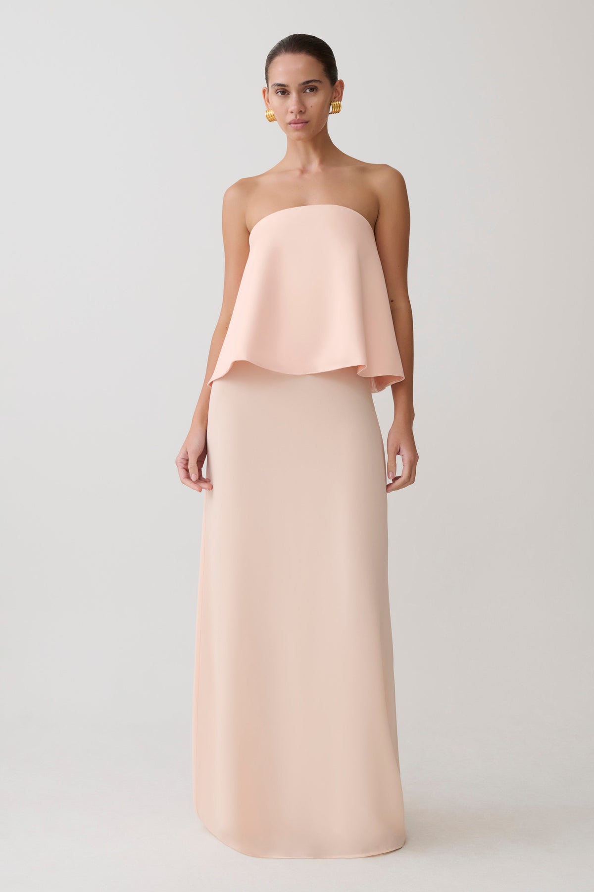 Woman wearing a strapless blush pink gown.