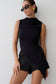 Woman wearing a black sleeveless top.