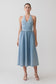 Woman wearing a light blue halter denim dress.