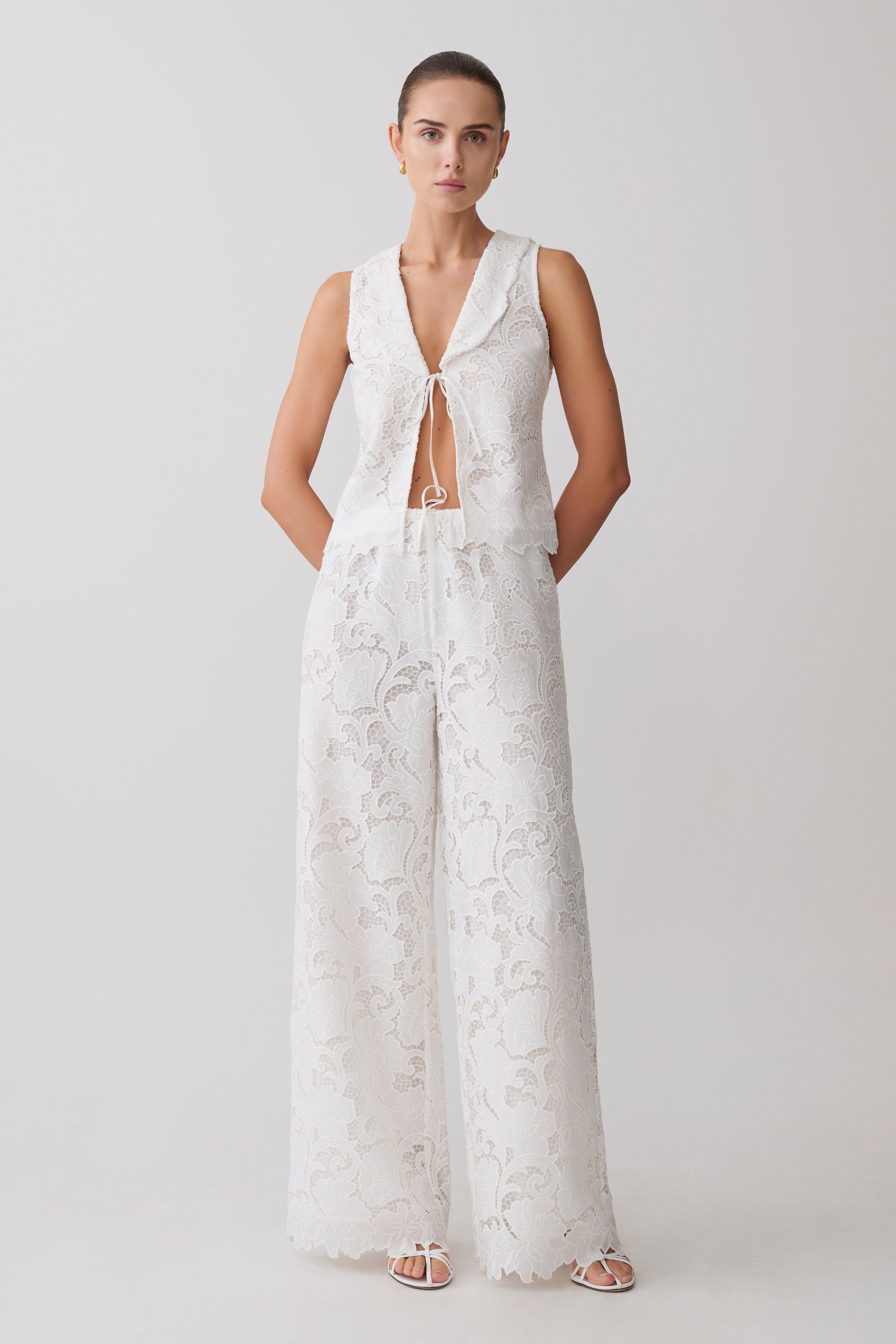 Woman wearing a white broderie tie top with matching pants.