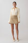 Woman wearing a cream blouse and beige skirt on a white background