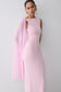 Woman wearing a pink gown with a sheer scarf overlay.