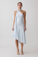 Woman wearing a light blue halter neck dress on a white background