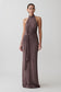 Woman wearing a long brown dress with a halter neck design on a white background