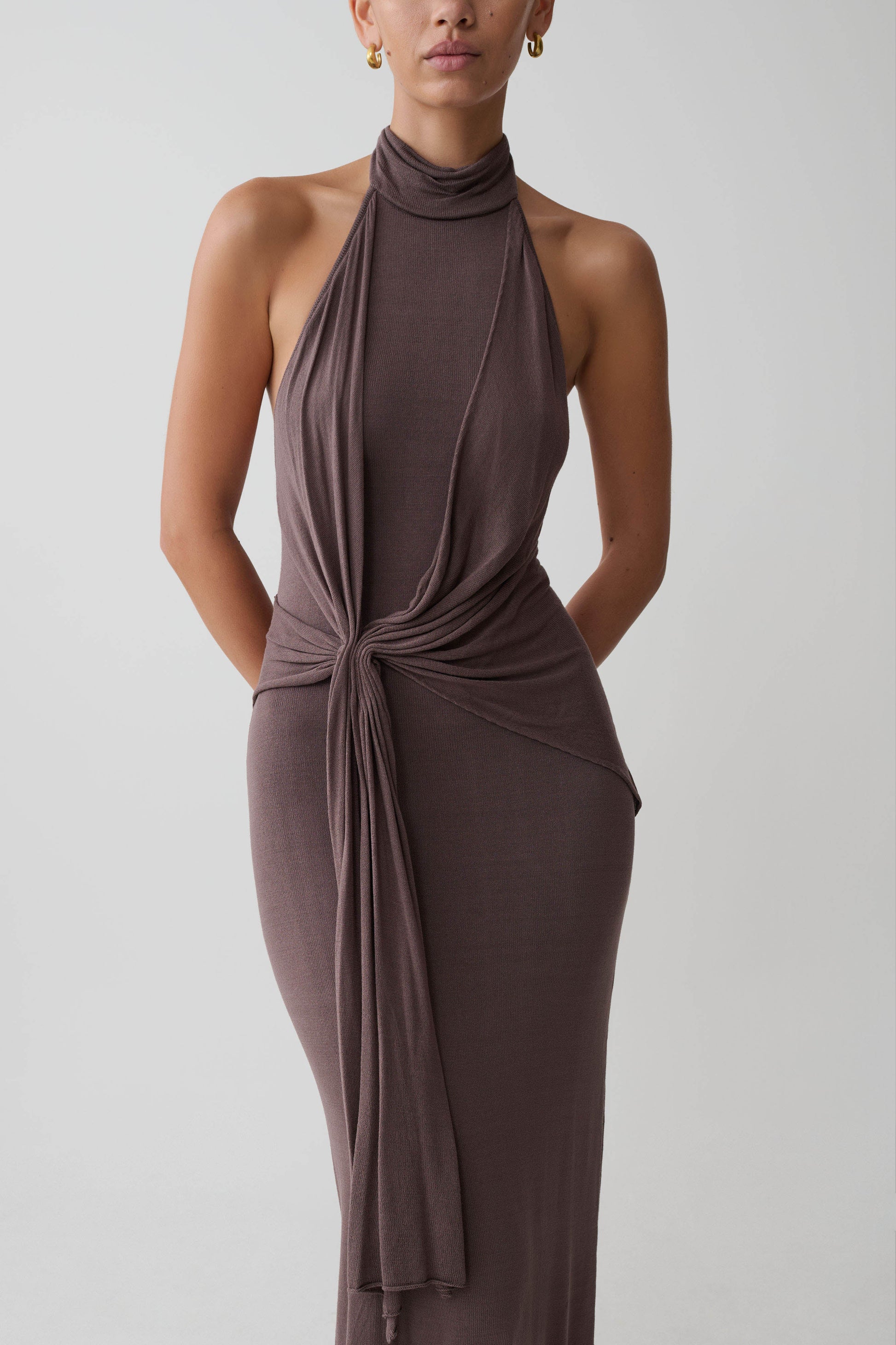 Woman wearing a brown halter neck dress.