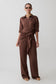 Woman wearing a brown jumpsuit on a white background