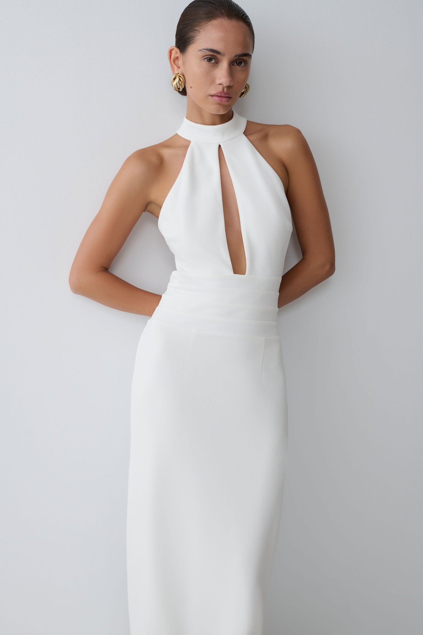 Woman wearing a white halter neck dress.