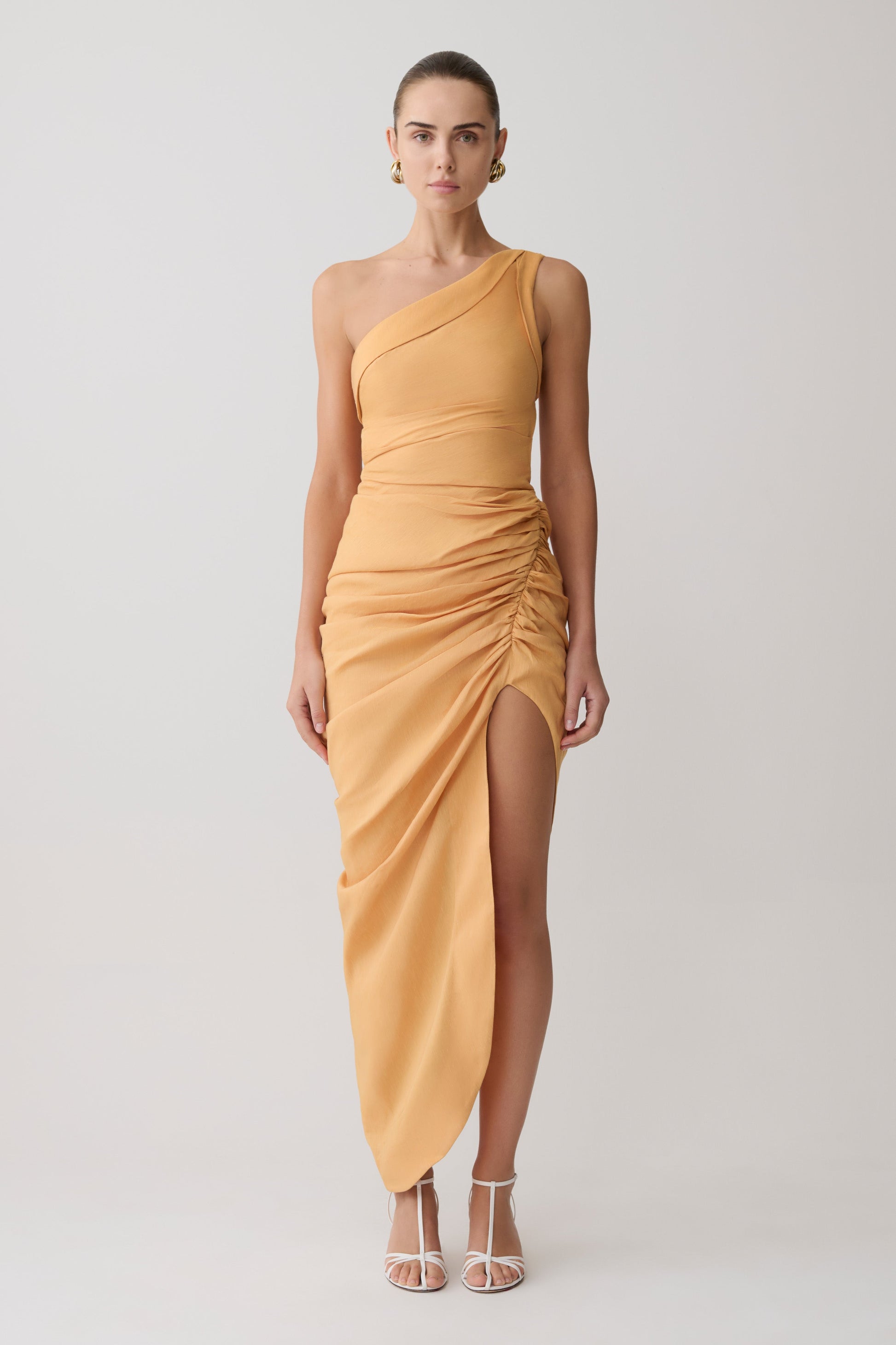 Woman wearing a yellow one-shoulder dress on a white background