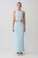 Woman wearing a light blue evening gown with lace details on a white background