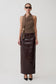 Woman wearing a brown top and dark brown leather skirt on a white background