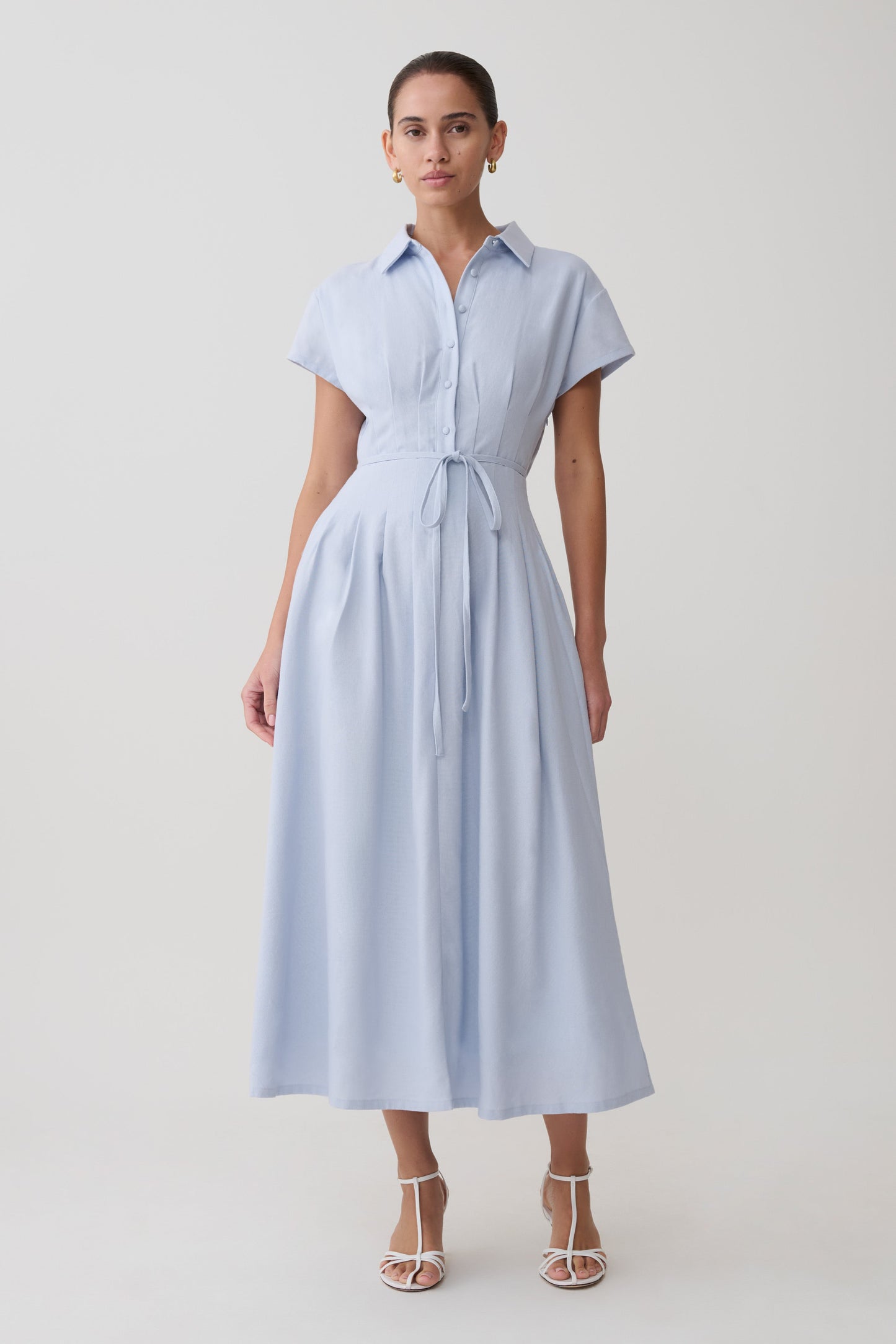 Woman wearing a light blue dress with a white background