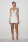 Woman wearing a white sequin dress on a plain background