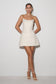 Woman wearing a white strapless dress against a plain background