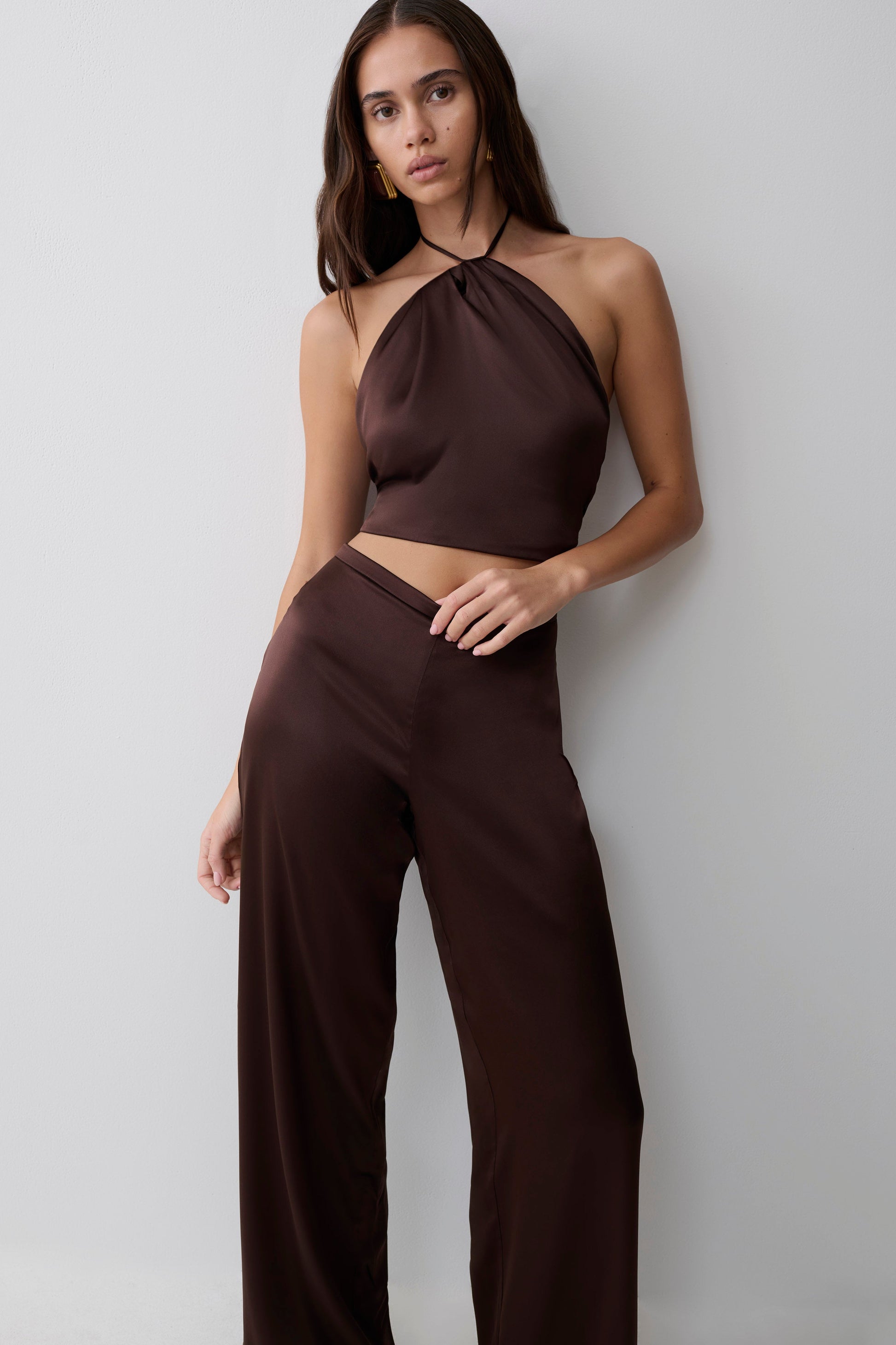 Woman wearing a brown silk halter top.