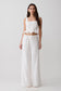 Woman wearing a white top and pant set.