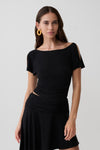 Woman wearing a black short sleeve off-shoulder top.