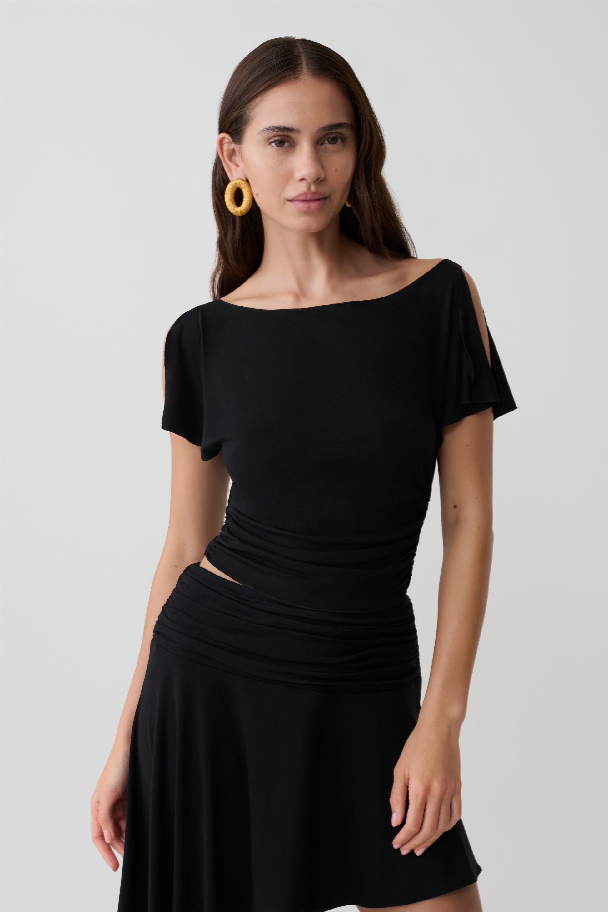 Woman wearing a black short sleeve off-shoulder top.