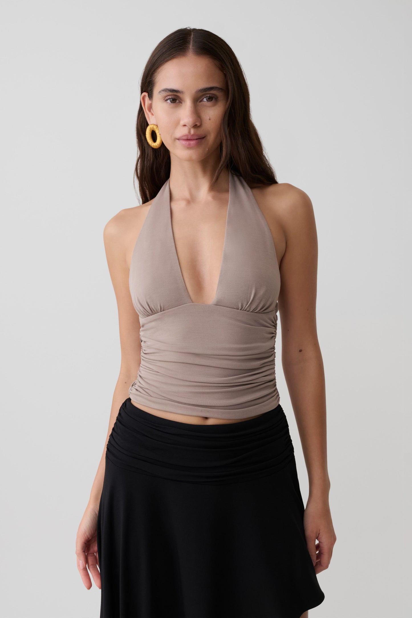 Woman wearing a brown modal gathered halter top. 