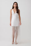Woman wearing a v neck white fringe maxi dress.