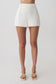 Woman wearing white shorts with lace trim.