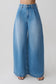 Woman wearing blue oversized jean with front pleat.