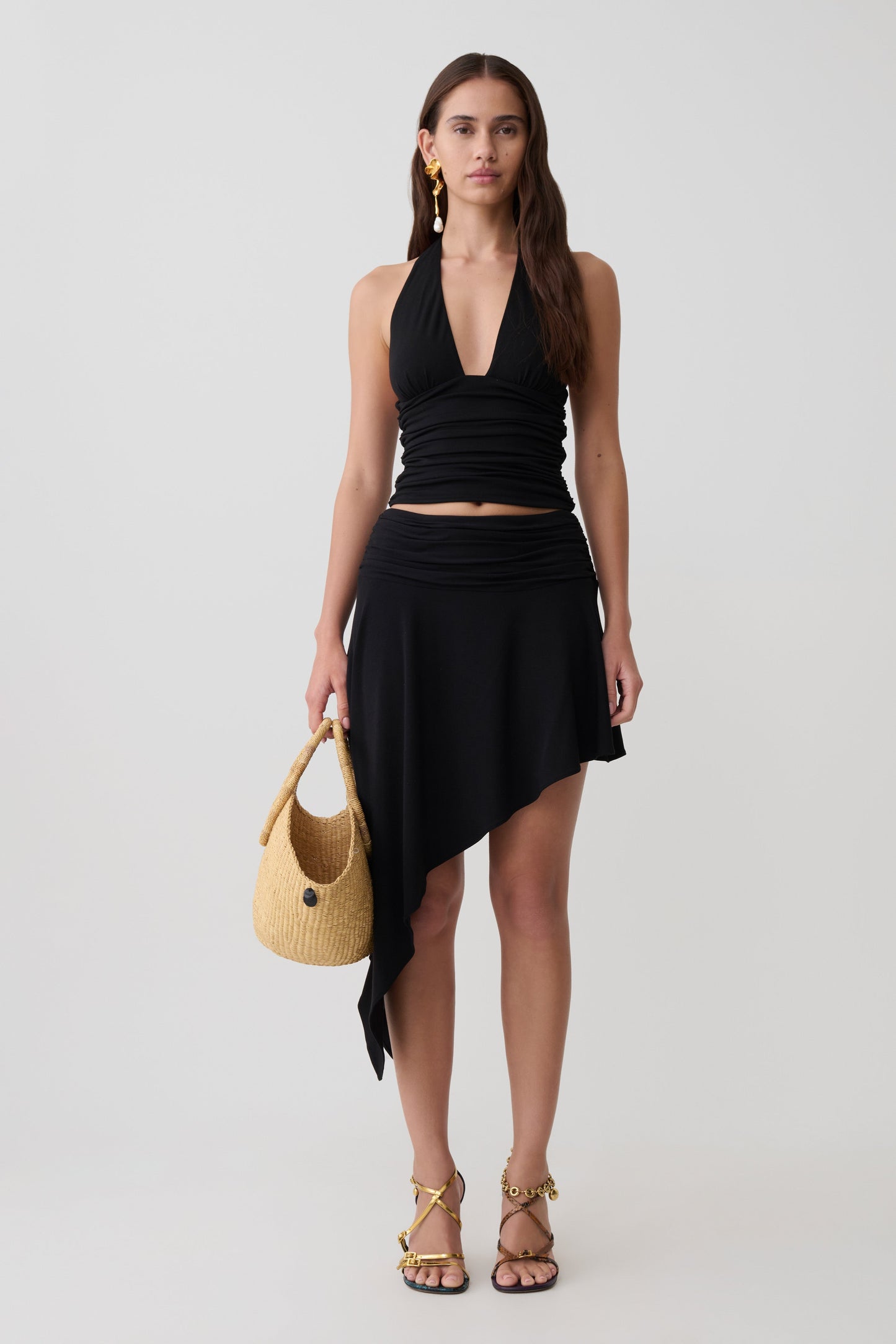 Woman wearing a black modal set with an asymmetrical midi skirt.