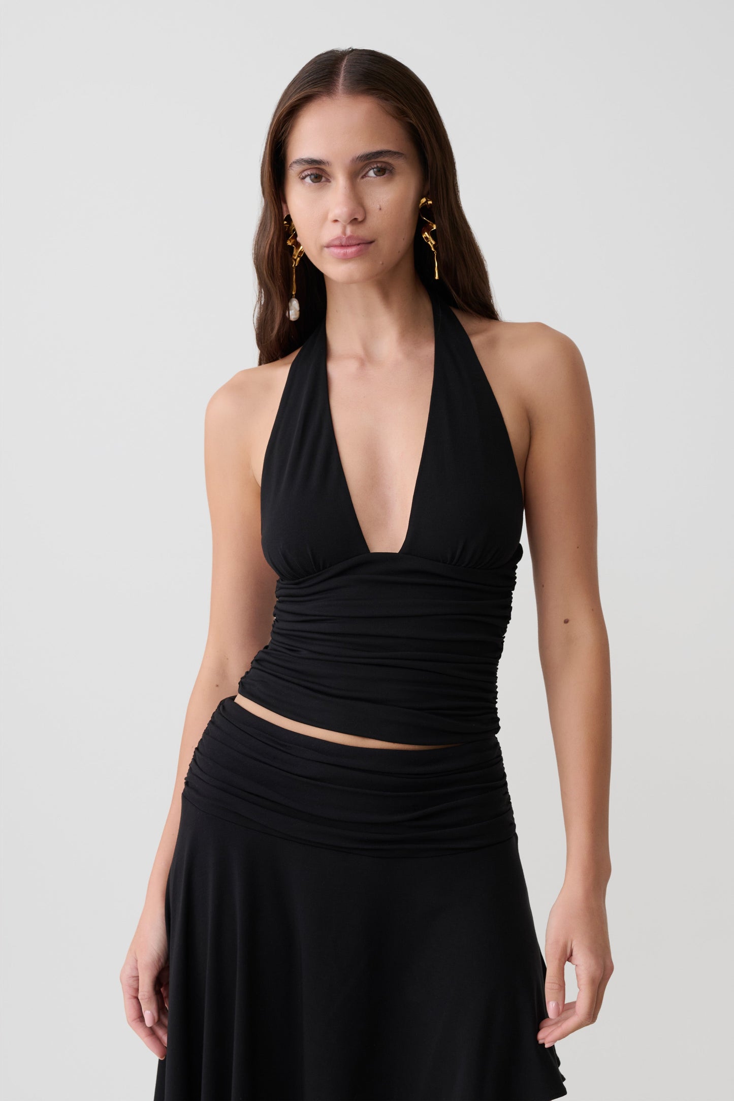 Woman wearing a black modal gathered halter top.