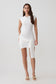 Woman wearing a white knit mini dress with sash.