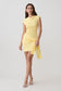 Woman wearing a yellow knit mini dress with sash.