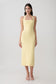 Woman wearing a yellow suiting halter midi dress.