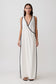 Woman wearing a white crossover cover up maxi dress with black trim.
