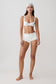 Woman wearing a white bikini set with micro shorts.