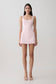Woman wearing a pink satin mini dress.