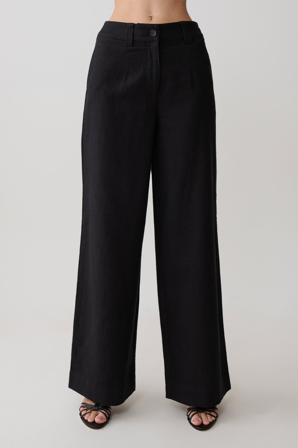 Woman wearing black straight leg linen pants.