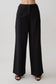 Woman wearing black straight leg linen pants.