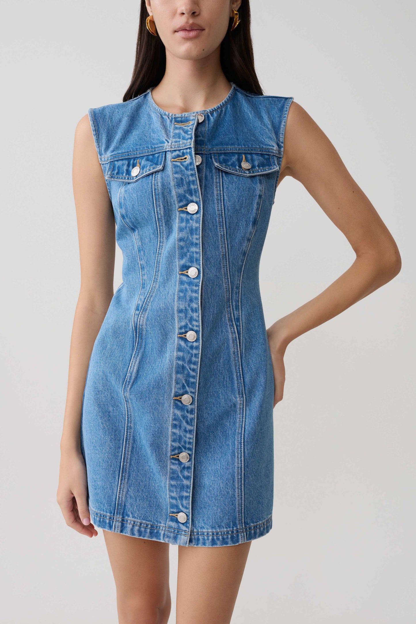 Woman wearing button front denim mini dress.