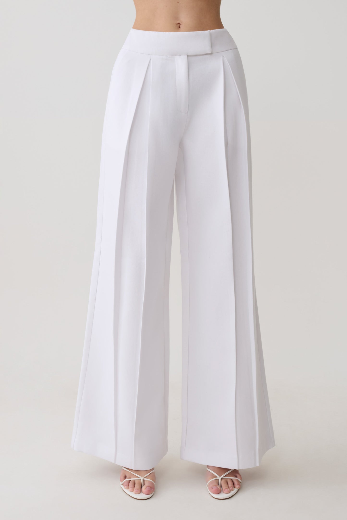 Woman wearing white mid rise wide leg pants.