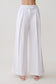 Woman wearing white mid rise wide leg pants.