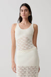 Woman wearing a white sleeveless crochet top.