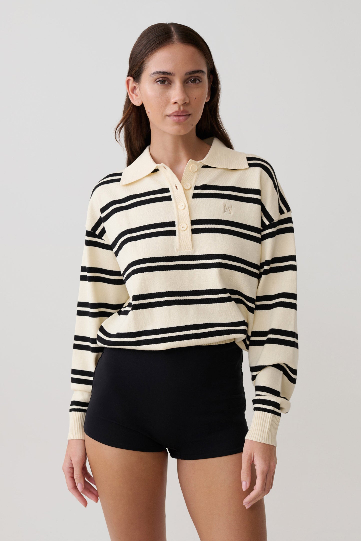 Woman wearing a black and white striped jumper with a collar.