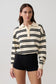 Woman wearing a black and white striped jumper with a collar.