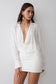Woman wearing a white cowl drape shirt dress.