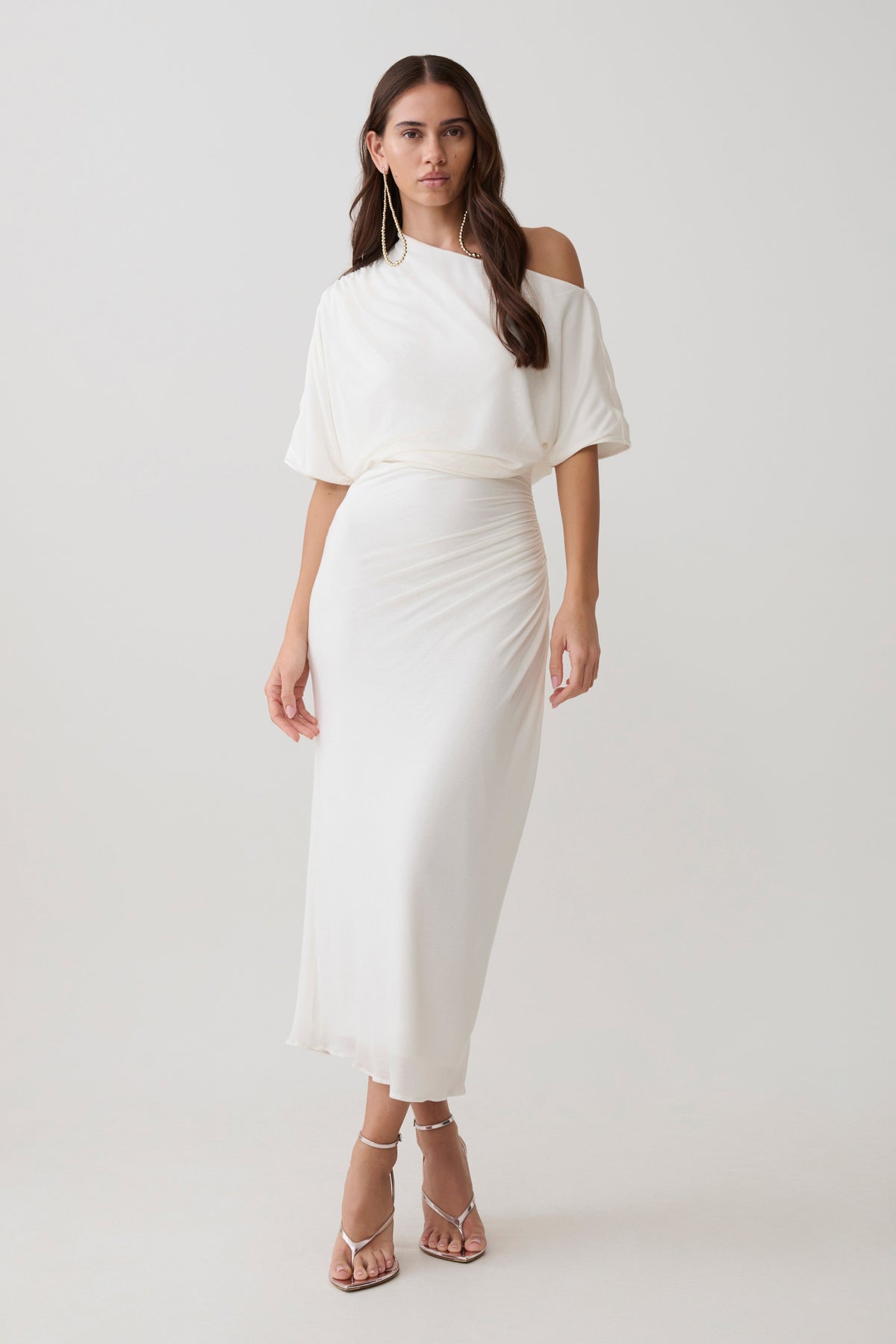Woman wearing a white off-shoulder midi dress.