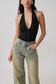 Woman wearing a black slinky halter bodysuit.
