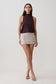 Woman wearing brown sleeveless modal draped bodysuit with a mini skirt.