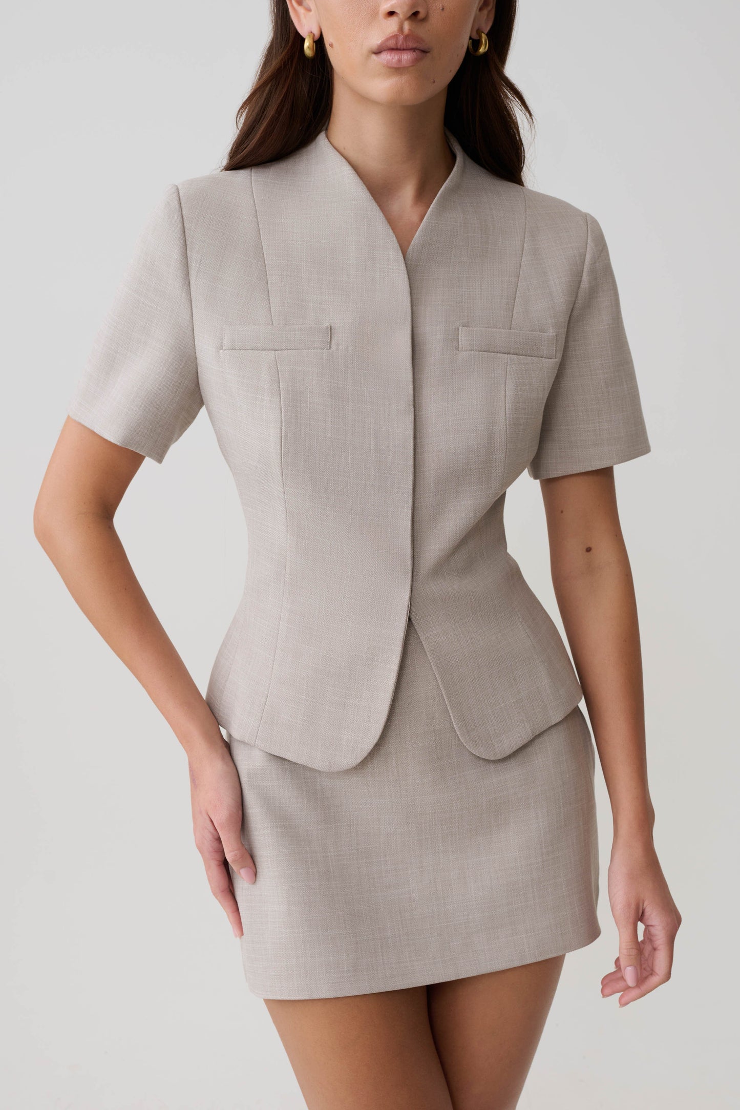 Woman wearing a grey suiting short sleeve top.