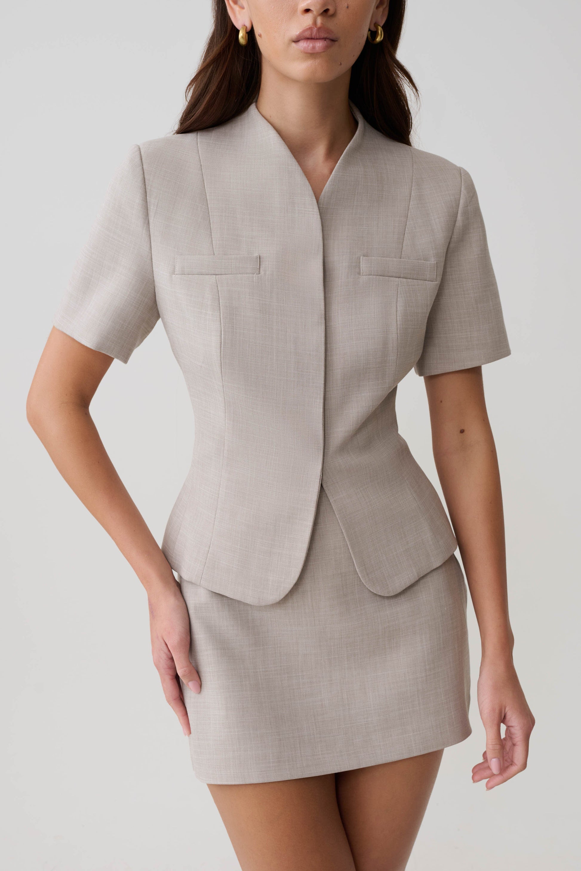 Woman wearing a grey suiting short sleeve top.