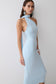 Woman wearing a light blue one shoulder tie midi dress.